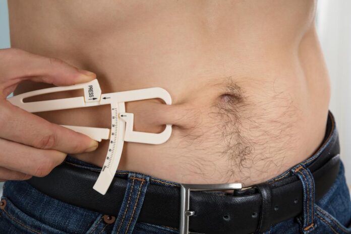 caliper-being-used-to-measure-body-fat-on-abdomen